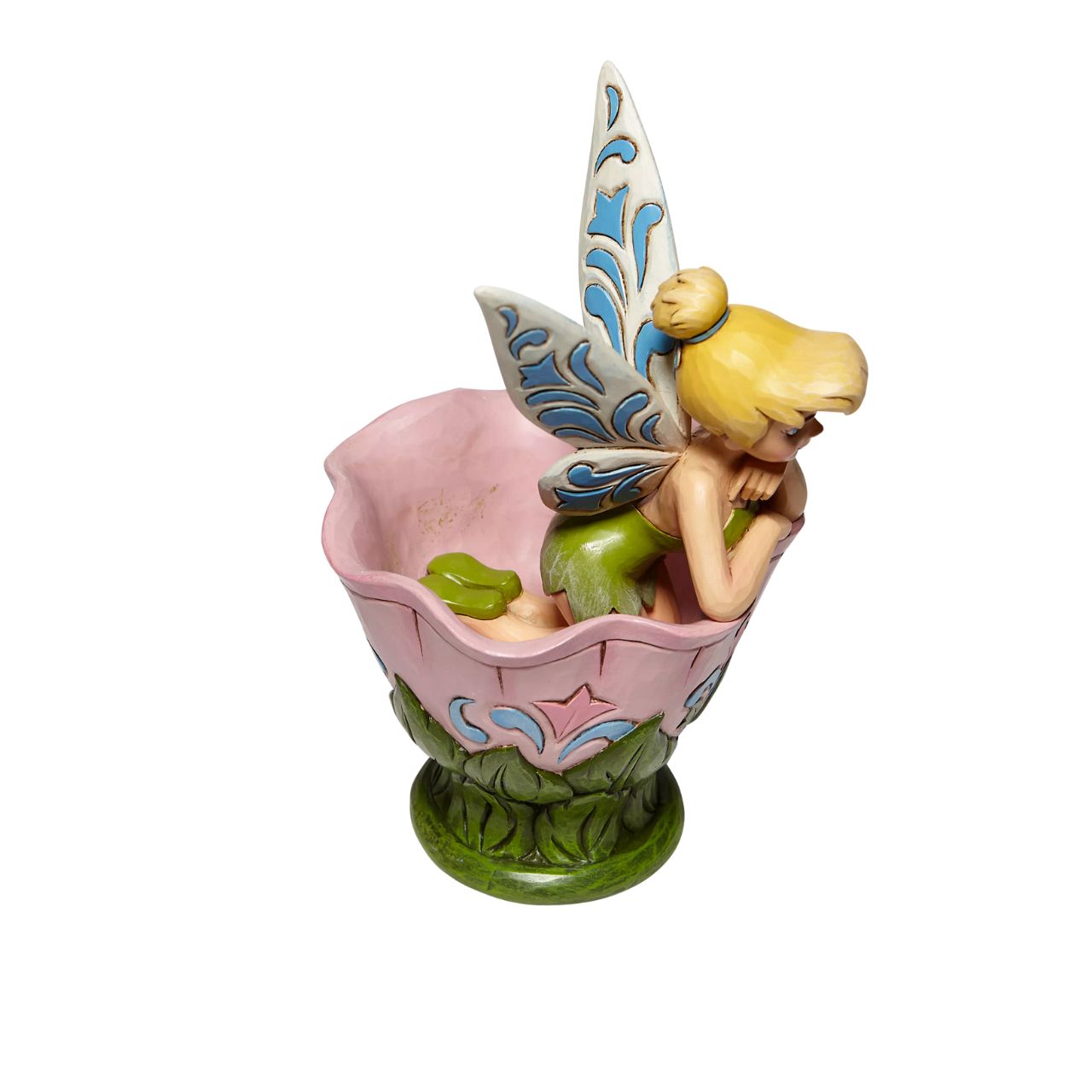 Disney Tinkerbell Sitting in a Flower Figurine A Spot of Tink by Jim Shore All the way from Neverland, this sweet and sassy fairy, takes a flower break before she's off on her next adventure. This Disney by Jim Shore piece is intricately hand sculpted and is great for any Tinker Bell enthusiast. Made from cast stone.