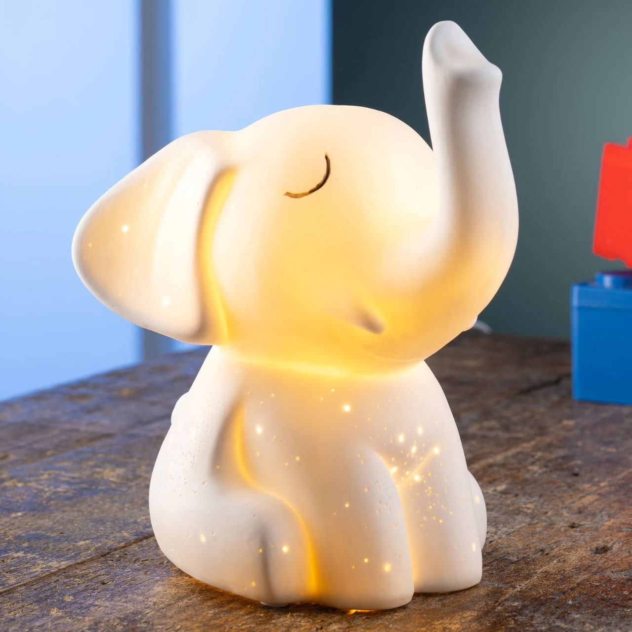 This charming elephant shaped luminaire features a raised trunk, a happy little face and pierced with a starlight pattern. When lit the porcelain body illuminates emitting a soft gentle glow highlighting all the details in this charming lamp, perfect for any animal lover.