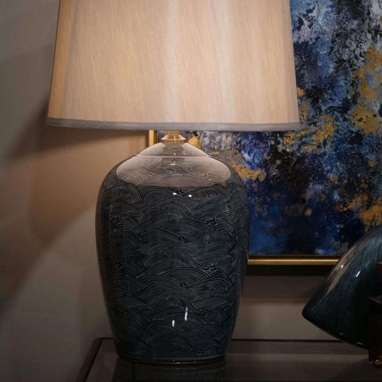 Blue Waves Lamp by Mindy Brownes Mindy Brownes Ceramic Lamp. Good lighting is essential for every home. Our ceramic collection is traditional yet timeless and featuring stunning designs, prints and patterns bursting with colour. This lamp features blue and navy wave details with a taupe linen shade.