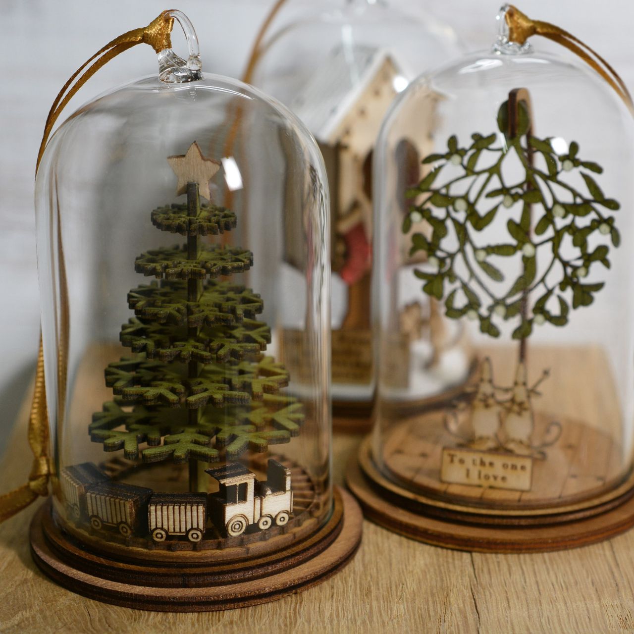 Christmas Childhood Memories Hanging Ornament Kloche The Spirit of Christmas. A collection of delightful wooden decorations that capture the essence of that special time of year. This glass dome, Christmas decoration encases a Christmas tree, adorned with a nostalgic train set and ribbon to help hang off your Christmas tree.