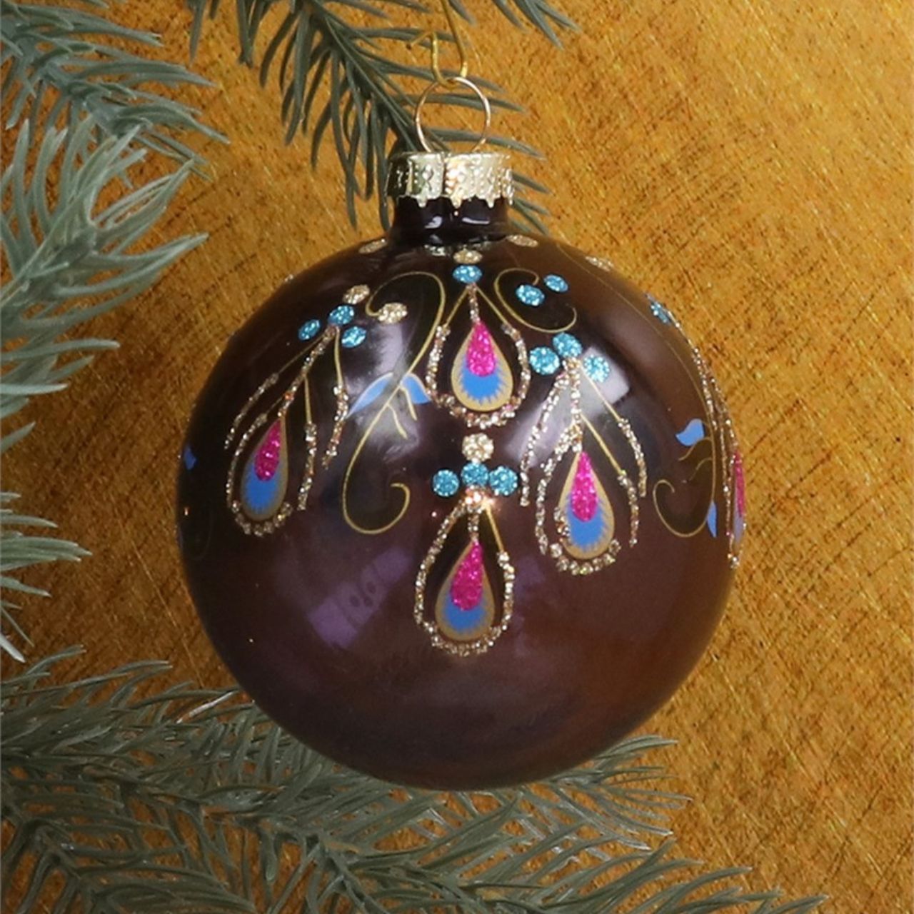 Expertly designed by Gisela Graham, these Christmas Baubles feature a beautiful blend of purple, pink, and blue colours with intricate peacock feather detailing. Elevate your holiday décor with these unique and eye-catching ornaments.