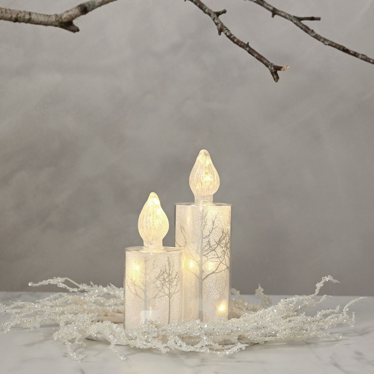 Christmas Silver Forest Scene Medium LED Glass Candle Light A medium silver forest scene LED candle-shaped light by THE SEASONAL GIFT CO. This glistening light will help to create a magical Winter Wonderland at home this festive period.