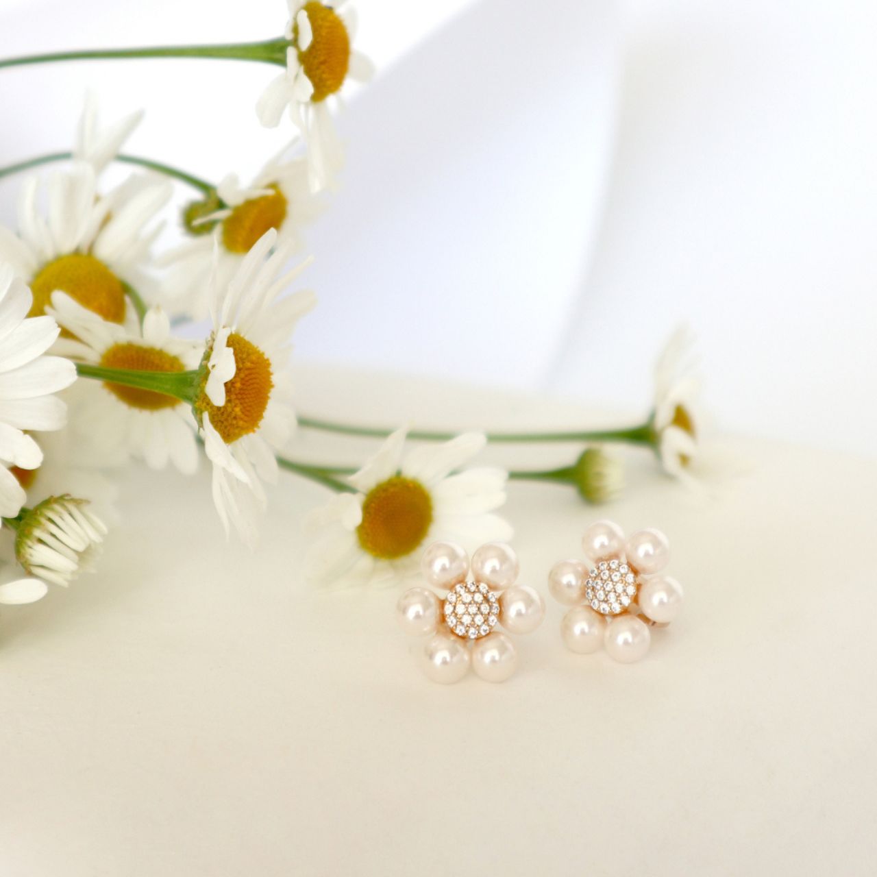 Elevate your elegance with these Tipperary Daisy Pink Pearl Stud Earrings. Featuring delicate 2cm gold studs adorned with soft pink pearls, they offer a refined touch that complements both everyday and special occasions.