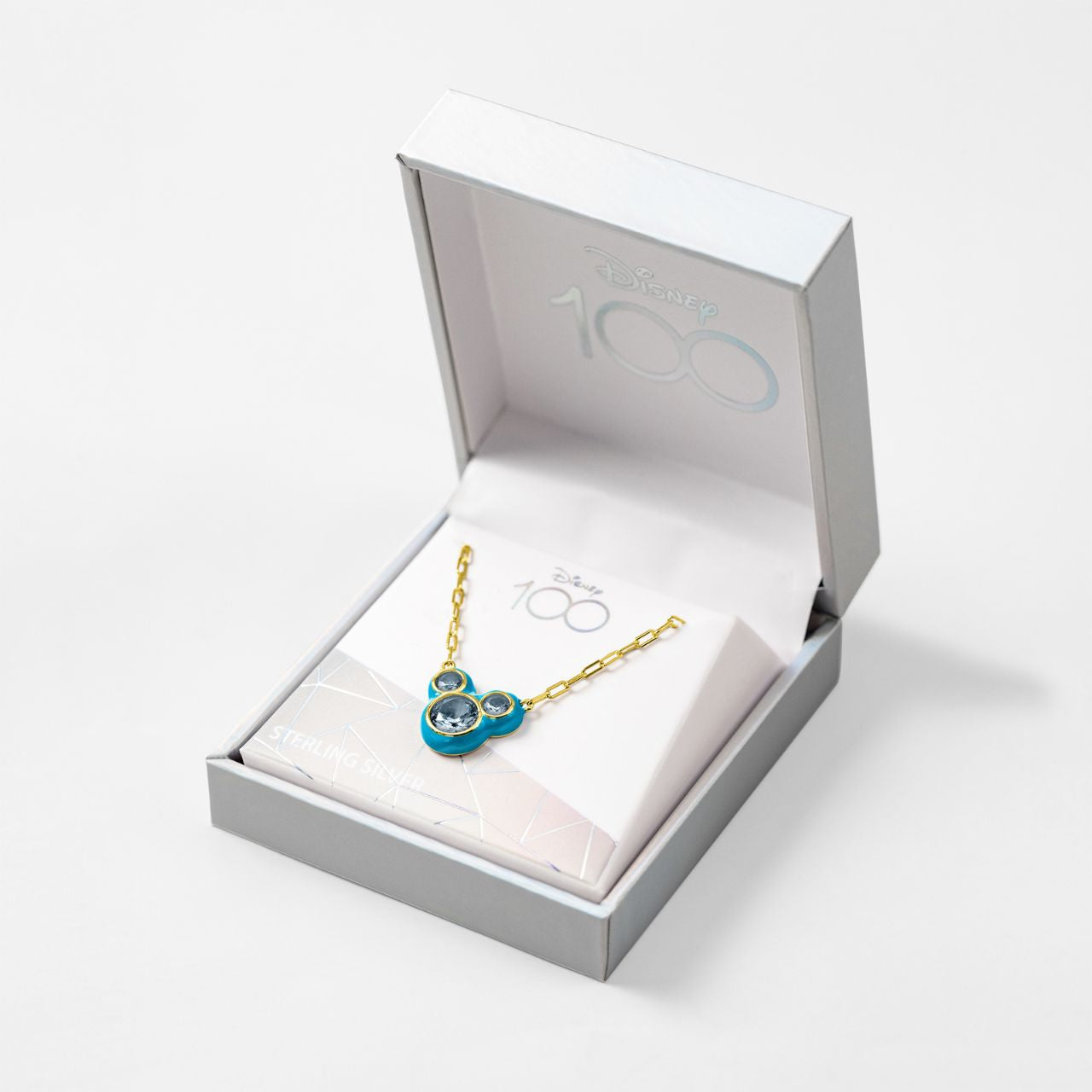 Disney 100th Anniversary Minnie Mouse Blue Back CZ Pendant This Disney Minnie Mouse Blue Back Necklace features a stunning CZ pendant showcasing everyone's favourite mouse. With its delicate and stylish design, this necklace is the perfect accessory for any Disney fan. Add a touch of magic to your everyday look with this charming piece.