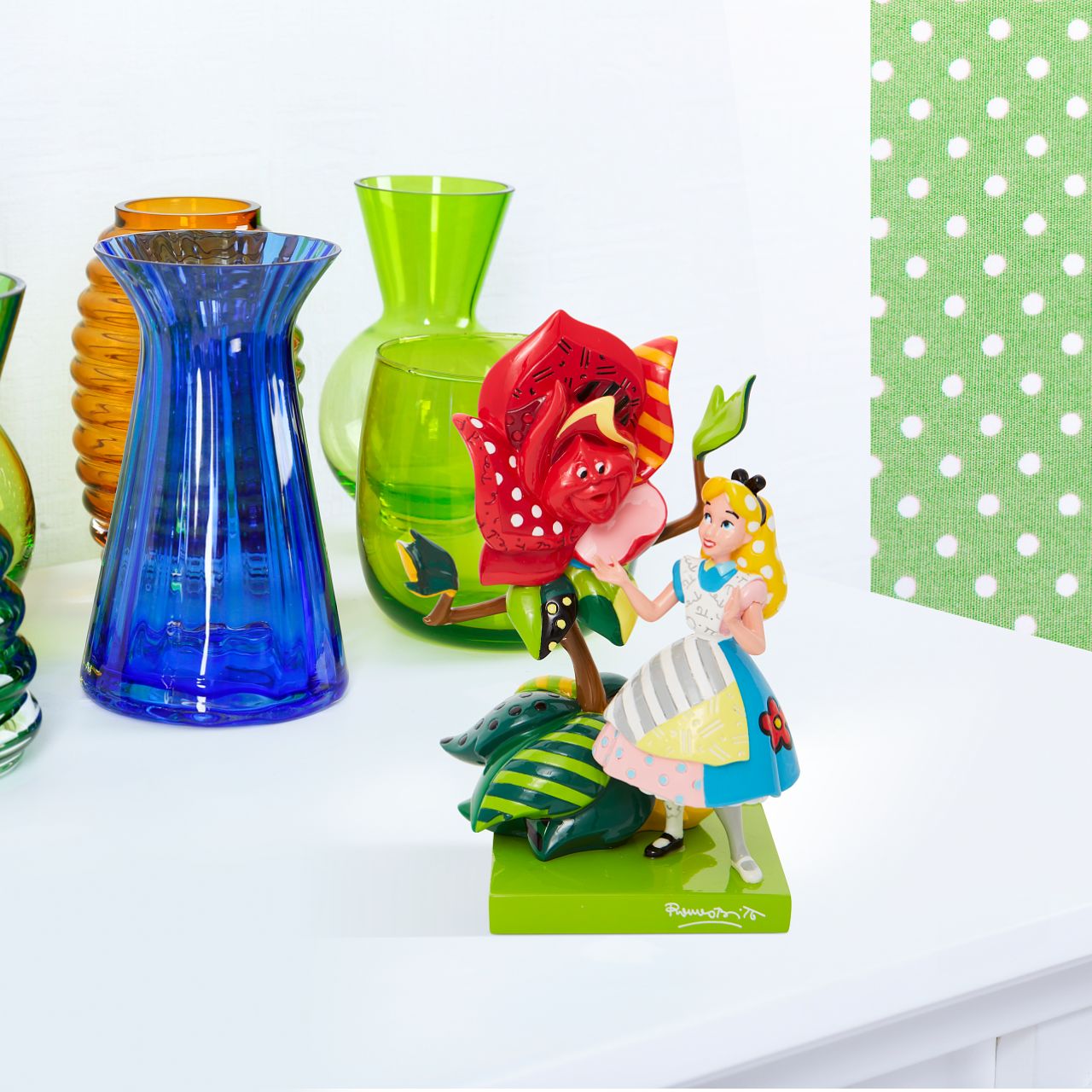 With bold colour and compelling pattern, contemporary pop artist Romero Britto captures the fun and whimsy of Disney. Redesigning a scene from Alice and Wonderland, Alice greets a talking rose with glittering grace.