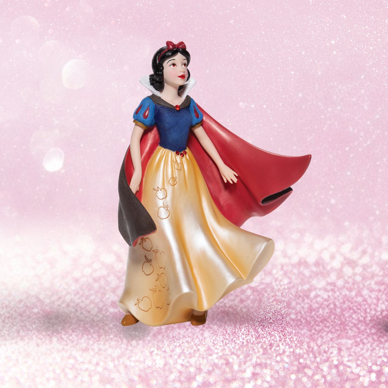 Snow White Couture de Force Figurine Snow White with her skin fair as snow and lips red as apples follows the wind on a new adventure fit for a princess. Hand-crafted and hand-painted, her iconic outfit shimmers in yellow satins and dark wool felts plussed with red faux gem stones.