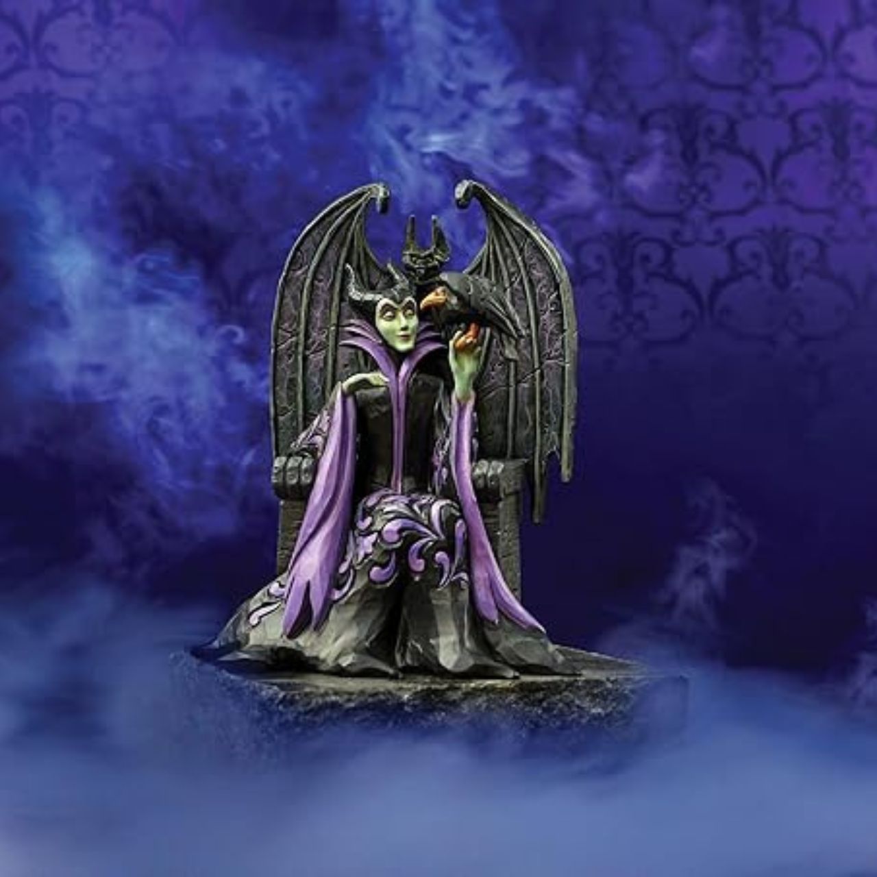 Maleficent sits atop her throne with her raven, Diavel. Dressed in her signature black with horned headdress, she is every piece the iconic villain from Sleeping Beauty. Designed by Jim Shore for his Disney Traditions collection.