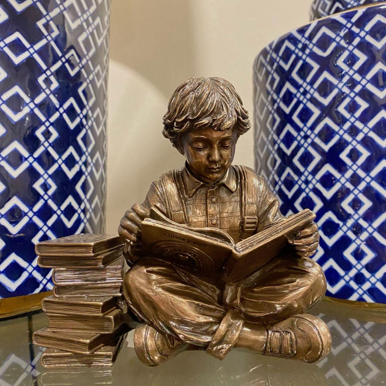 Discover a scene that resonates with the tranquillity of learning, a young boy engrossed in a world of imagination, sitting beside a stack of cherished books.