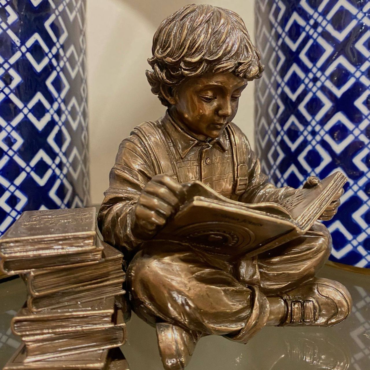 Discover a scene that resonates with the tranquillity of learning, a young boy engrossed in a world of imagination, sitting beside a stack of cherished books.