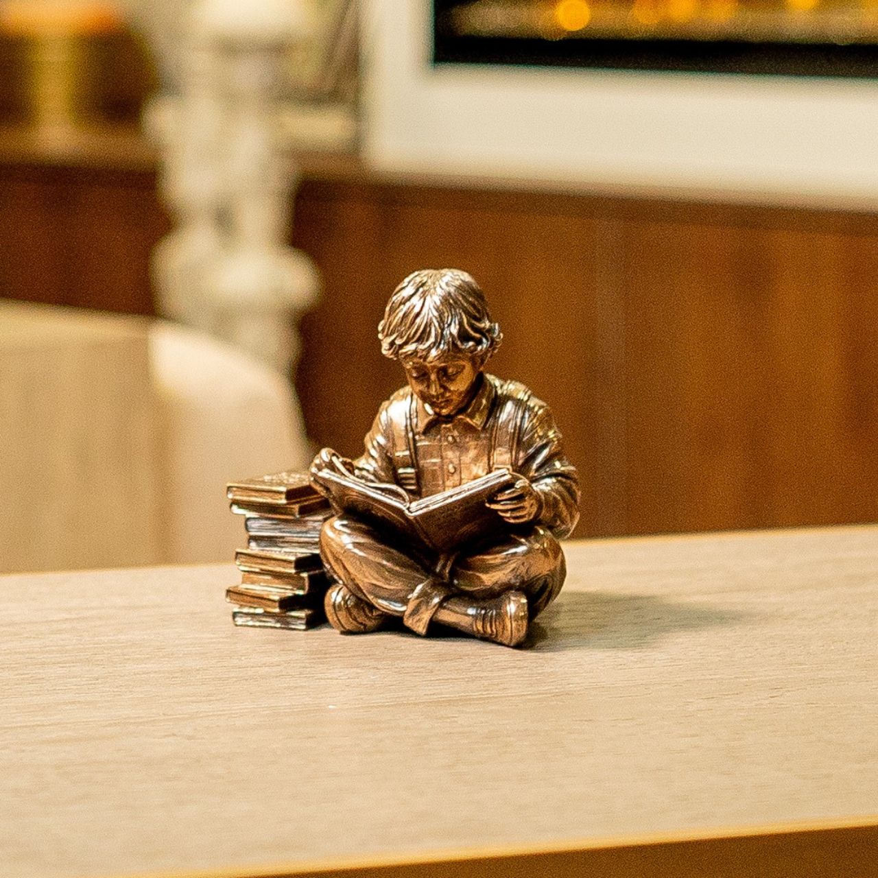 Discover a scene that resonates with the tranquillity of learning, a young boy engrossed in a world of imagination, sitting beside a stack of cherished books.
