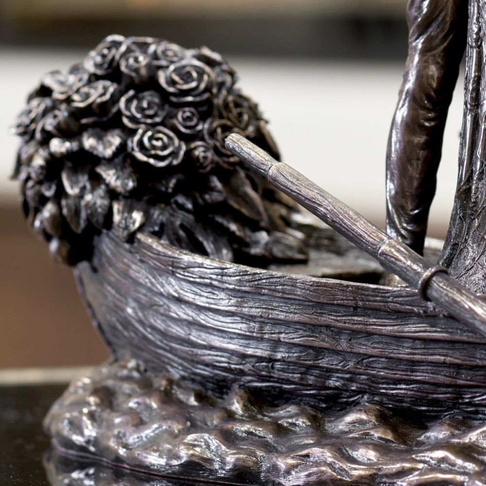 Love Boat by Genesis Ireland  A beautiful bronze coloured statue of a couple on their wedding day, sailing away in their love boat.