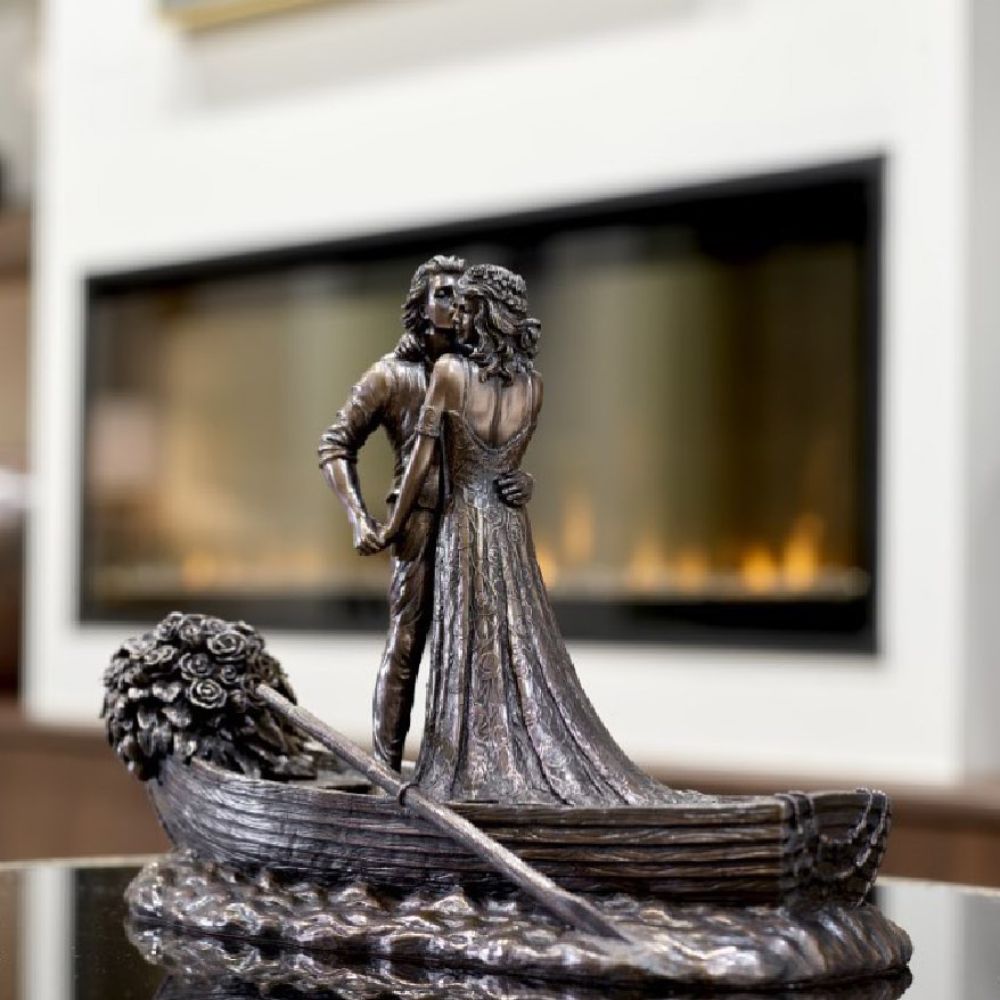 Love Boat by Genesis Ireland  A beautiful bronze coloured statue of a couple on their wedding day, sailing away in their love boat.