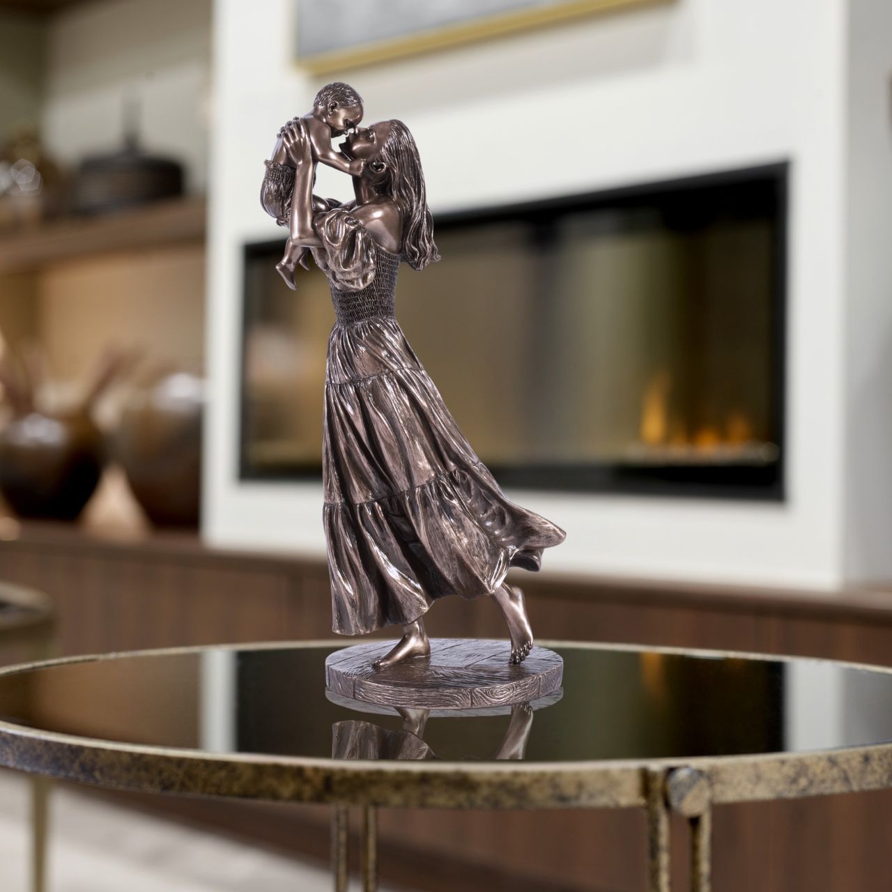 Celebrate the bond of motherhood with this heart-warming sculpture. It features a mother joyfully lifting her child in the air, capturing a moment of pure love and connection. A beautiful addition to any home or office décor.