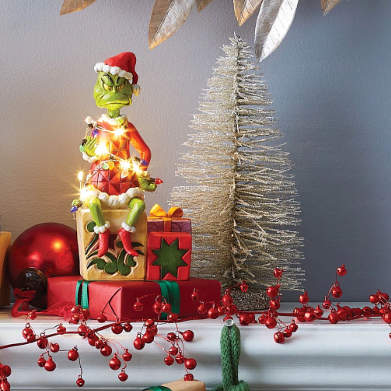 Grinch with lights Figurine - The Grinch  With a grimace on his green grouchy face, the Grinch, by Jim Shore, finds himself wrapped in a glowing string of lights as he tries to ruin the holiday.