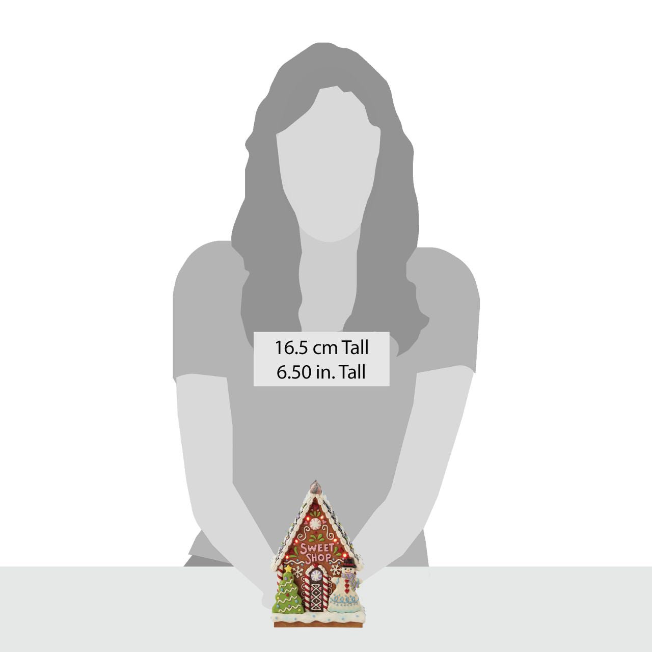 This enchanting Jim Shore LED light-up sweet shop invites you into a festive gingerbread house with colourful icing, cookies, and candy. Glowing warmly, it promises a world of delicious treats and holiday cheer, making it a delightful centerpiece.