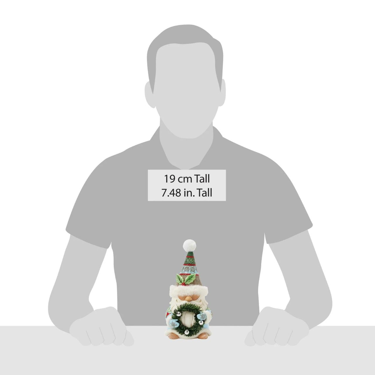 This festive Jim Shore gnome embodies holiday charm with a cozy hat with faux fur trim, intricate rosemaling, and snowflake patterns. Carrying a beautifully decorated wreath, he exudes warmth and joy bringing the spirit of Christmas to any space.