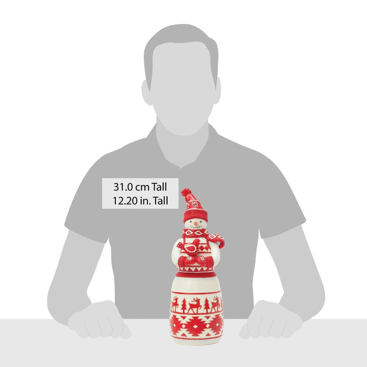 This sweet Jim Shore Nordic Noel snowman features bold red Nordic-inspired patterns, on his body, gloves, cosy scarf, and knitted hat. Holding a delicate cardinal bird in his hands, the snowman boasts whimsical trees and reindeer with a loving smile.