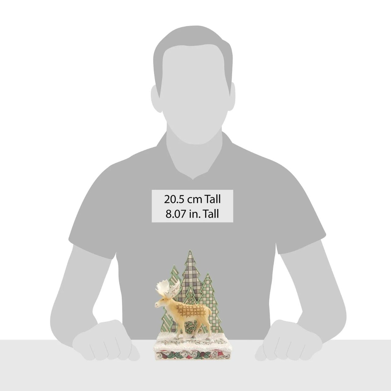 This captivating Jim Shore design features a majestic moose adorned with the artist's signature patchwork patterning on his hide, standing against a backdrop of uniquely patterned trees. With intricate details, it captures the peace of the forest.