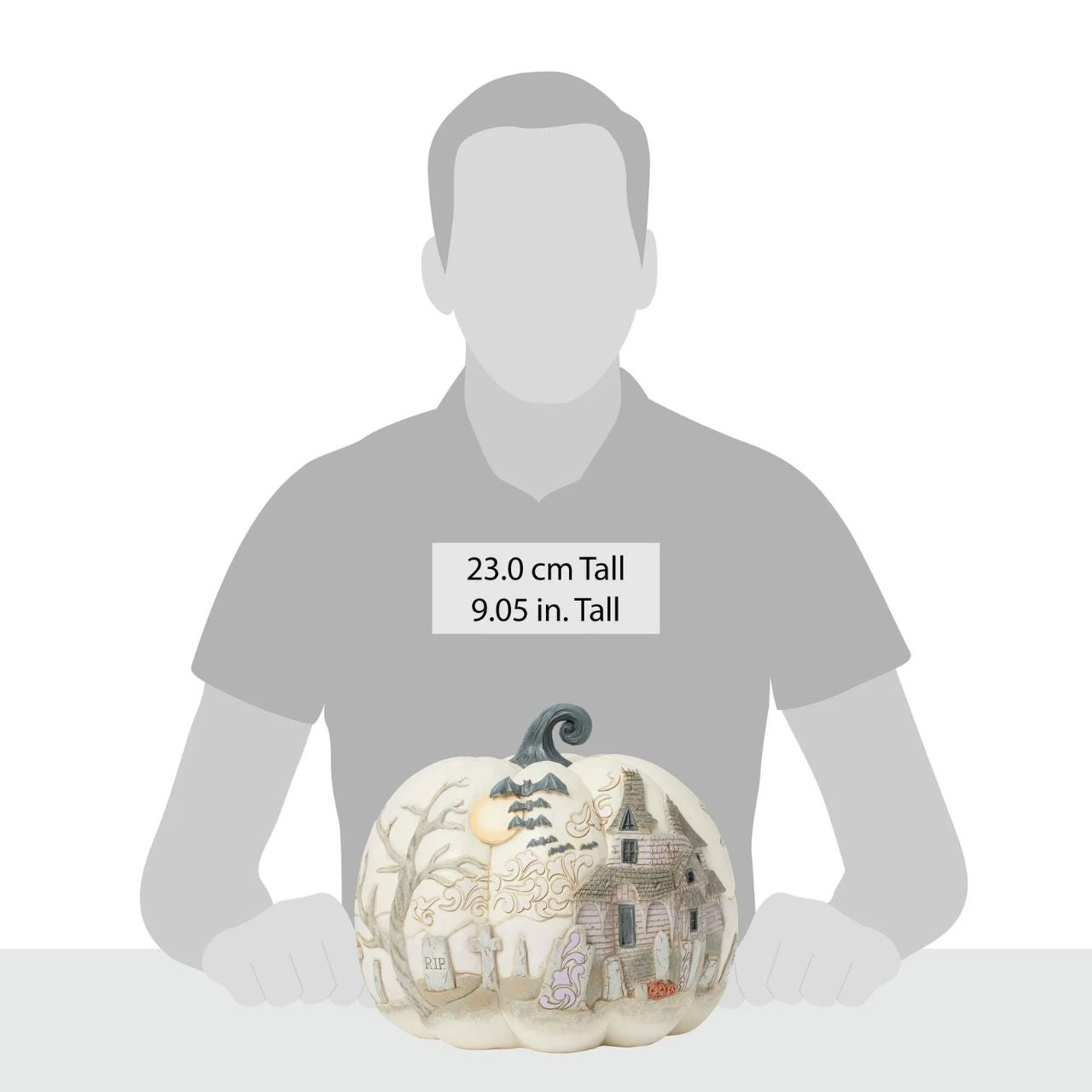 Capture the spirit of Halloween with this eerie Jim Shore pumpkin figurine, showcasing a haunted graveyard scene complete with a spooky haunted house, flying bats, and a full moon. With intricate details and haunting ambiance, prepare to scare.