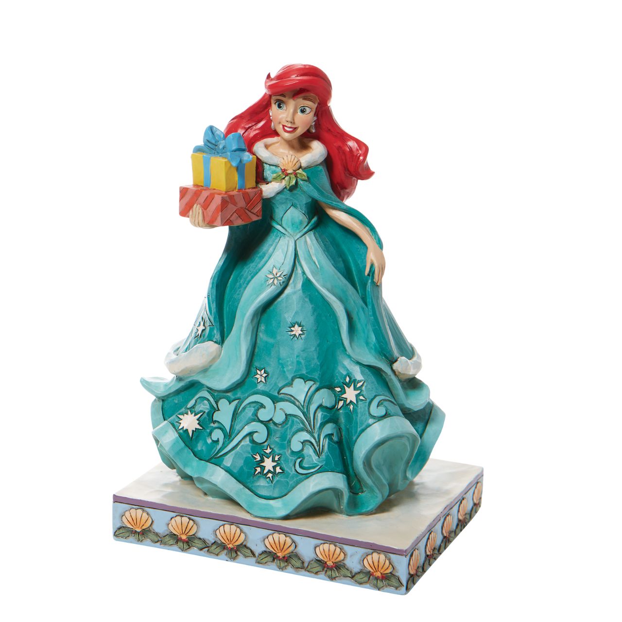 Jim Shore Ariel Little Mermaid with Gifts Figurine - Gifts of Song In a brilliant blue dress, Ariel is a vision of beauty and gratitude in this lovely Jim Shore statuette. Carrying gifts and wearing a broach of holly, the princess delivers presents to all those Under the Sea. Flounder and Sebastian grace the base. Hand painted and hand sculpted from high quality cast stone.