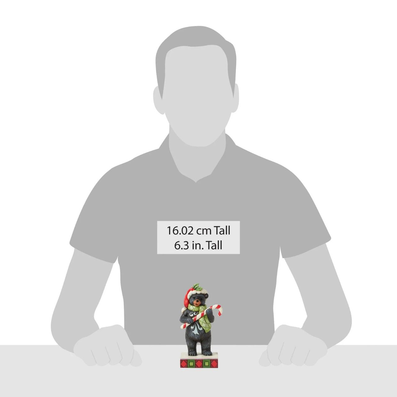 This playful Christmas at the Lodge Jim Shore black bear wears a festive Santa hat adorned with holly, he wears a festive scarf and holds a candy cane in his paws. With rosemaling designs on his fur, the piece brings sweet holiday fun and rustic charm to to any display.