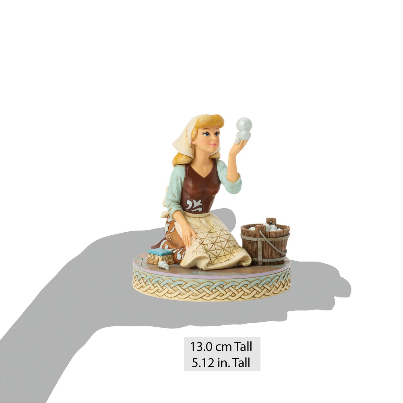 Cinderella's spirit remains unbroken in this inspiring Jim Shore scene. Dressed as a maid, she finds joy in her work, catching a bubble as she scrubs the floors. Jim Shore's enchanting details capture her beauty and resilience.