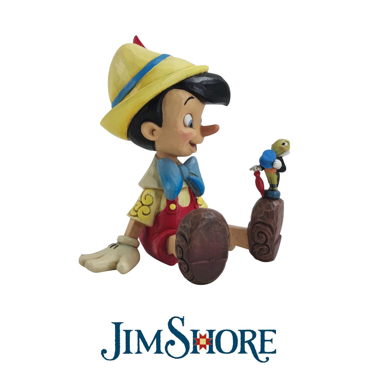 Pinocchio and Jiminy Sitting Figurine by Jim Shore "Wishful and Wise" Jiminy Cricket is quite the dapper conscience in this design by Jim Shore, giving a tip o' his top hat as he smiles and gives his bestie Pinocchio a lesson about temptations.