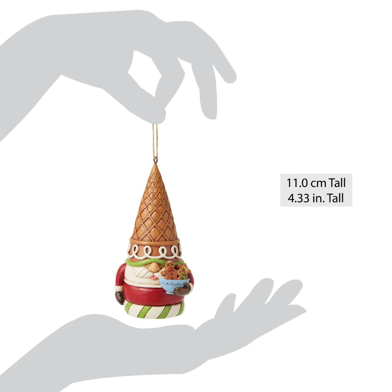 This whimsical Jim Shore Gingerbread Christmas ornament presents a charming gingerbread gnome, adorned with red and green icing and sprinkles, wearing an ice cream cone as a hat. Holding a bowl of candy, he'll bring a sweet and festive spirit to your holiday.