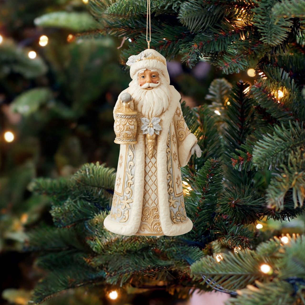 Holiday Lustre Santa Hanging Ornament Santa sparkles in this holiday ornament by Jim Shore. Holding a lantern and cloaked in a striking suit fitted with metallic accents, Santa shines this season. With a smile and glittering poinsettias, Father Christmas radiates joy.