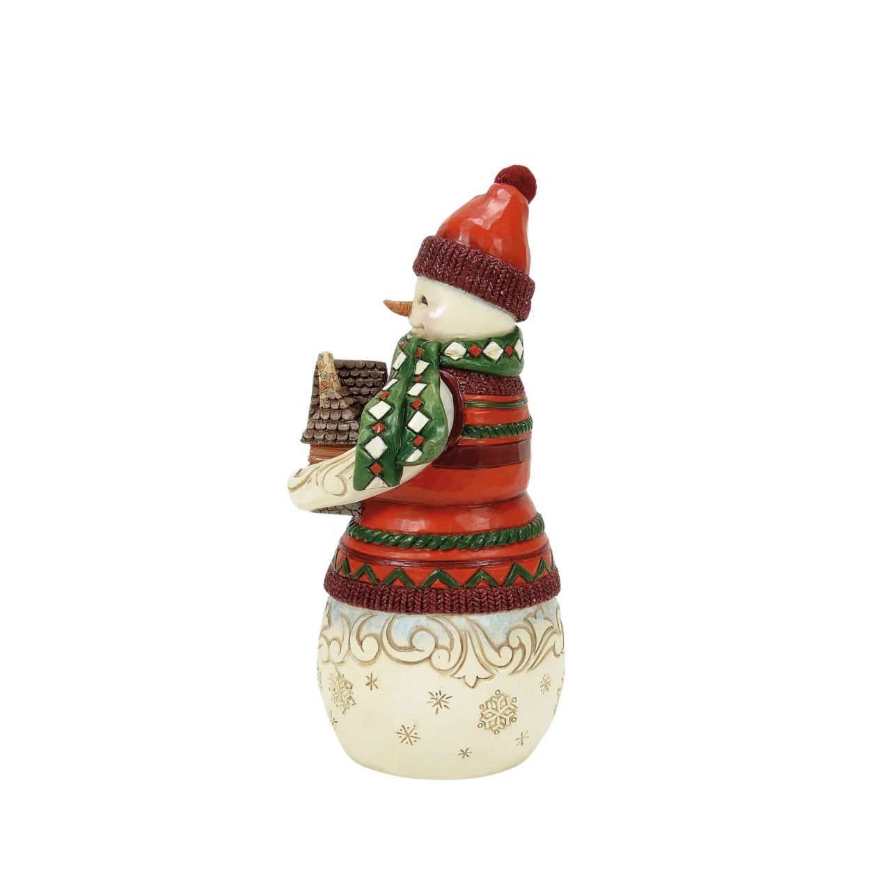 This Christmas at the Lodge Jim Shore snowman is dressed in an intricate red and green tunic and holds a little log cabin. With a knit cap, rosy cheeks, and a joyful smile, he glows with rosemaling and snowflakes, bringing festive warmth and cosy cabin vibes.