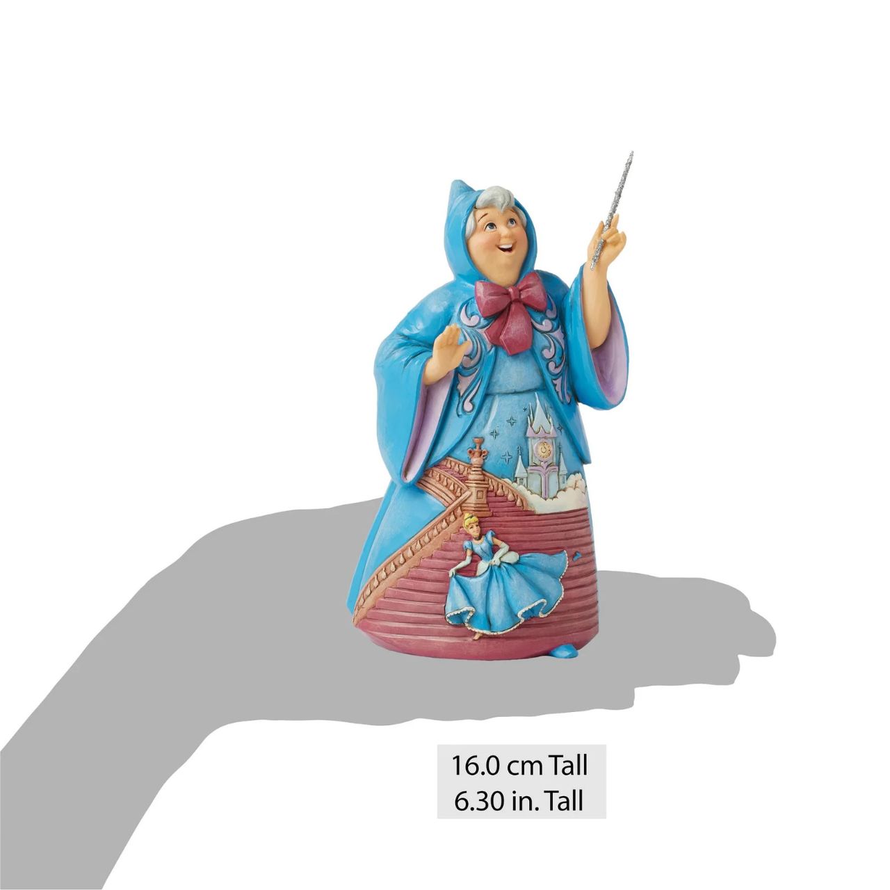 In this magical Jim Shore design, the Fairy Godmother smiles with her wand, her rosemaling blue robes parting to reveal Cinderella racing down the steps as the clock strikes midnight. This captivating moment is when she will lose her glass slipper.