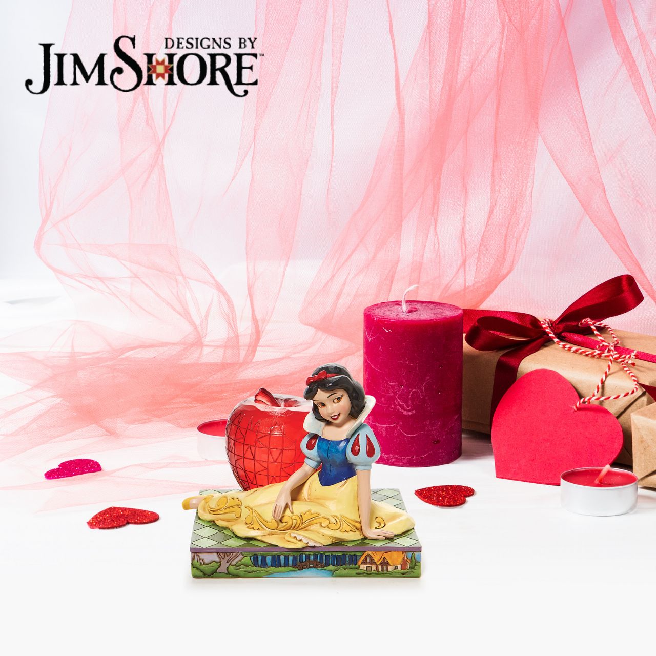 Disney Traditions Snow White with Apple Figurine  This Disney Traditions line by Jim Shore features iconic Walt Disney princesses with their famous props. With a base illustrating her story, this piece features Snow White in her famous gown next to a large apple.
