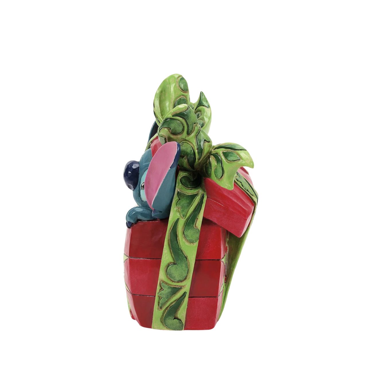 In this playful Jim Shore design, Stitch the alien bursts out of a vibrant Christmas present, showcasing his mischievous grin as he tears through festive wrapping. With his joyful chaos, Stitch proves that his lively presence is the best gift of all.