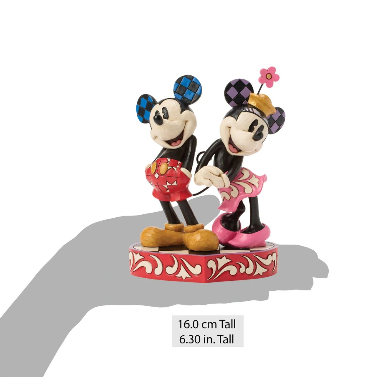 This romantic Disney design by Jim Shore features Mickey and Minnie Mouse, adorned with rosemaling and patchwork details. They stand on a heart-shaped base radiating the warmth of their timeless affection.