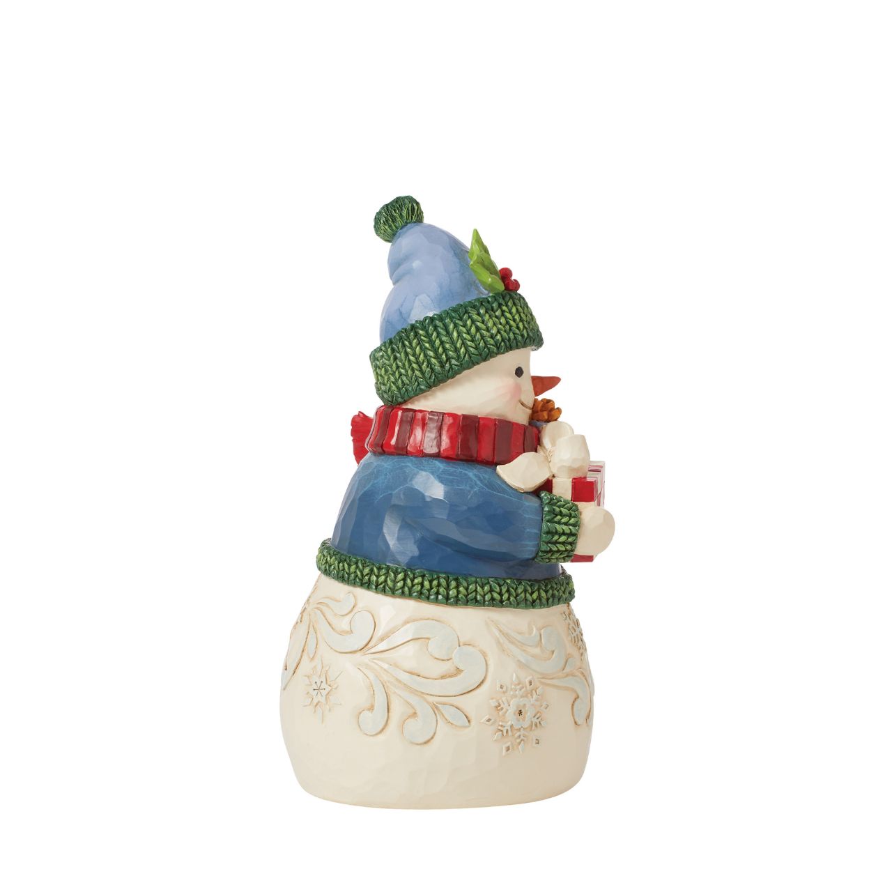 This charming snowman figurine by Jim Shore inspires holiday happiness. Keeping warm wearing a knitted sweater, holly trim hat, and billowing red scarf this snowman boasts rosy cheeks in the chilled air. He smiles with arms full.