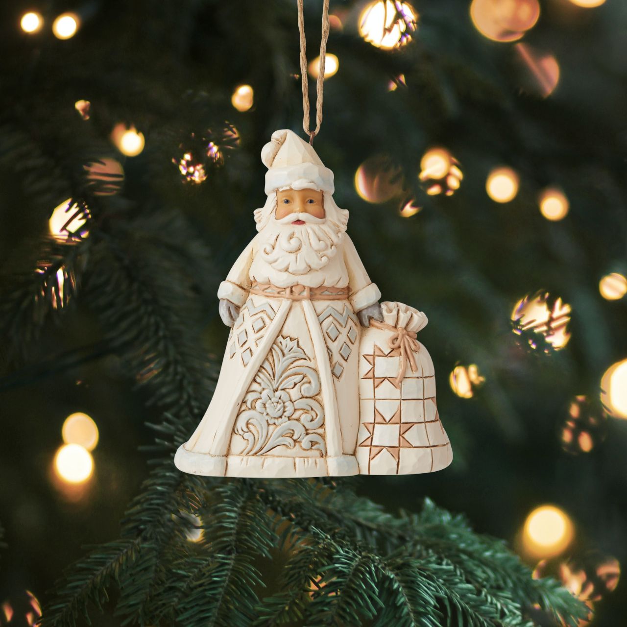 Heartwood Creek White Woodland Santa Hanging Ornament In muted colors, this cool hued Santa brings grandeur with his deliveries. With a bag heavy with presents, this Christmas hero smiles happily from your tree, admiring the nice boys and girls as they open presents in your home.