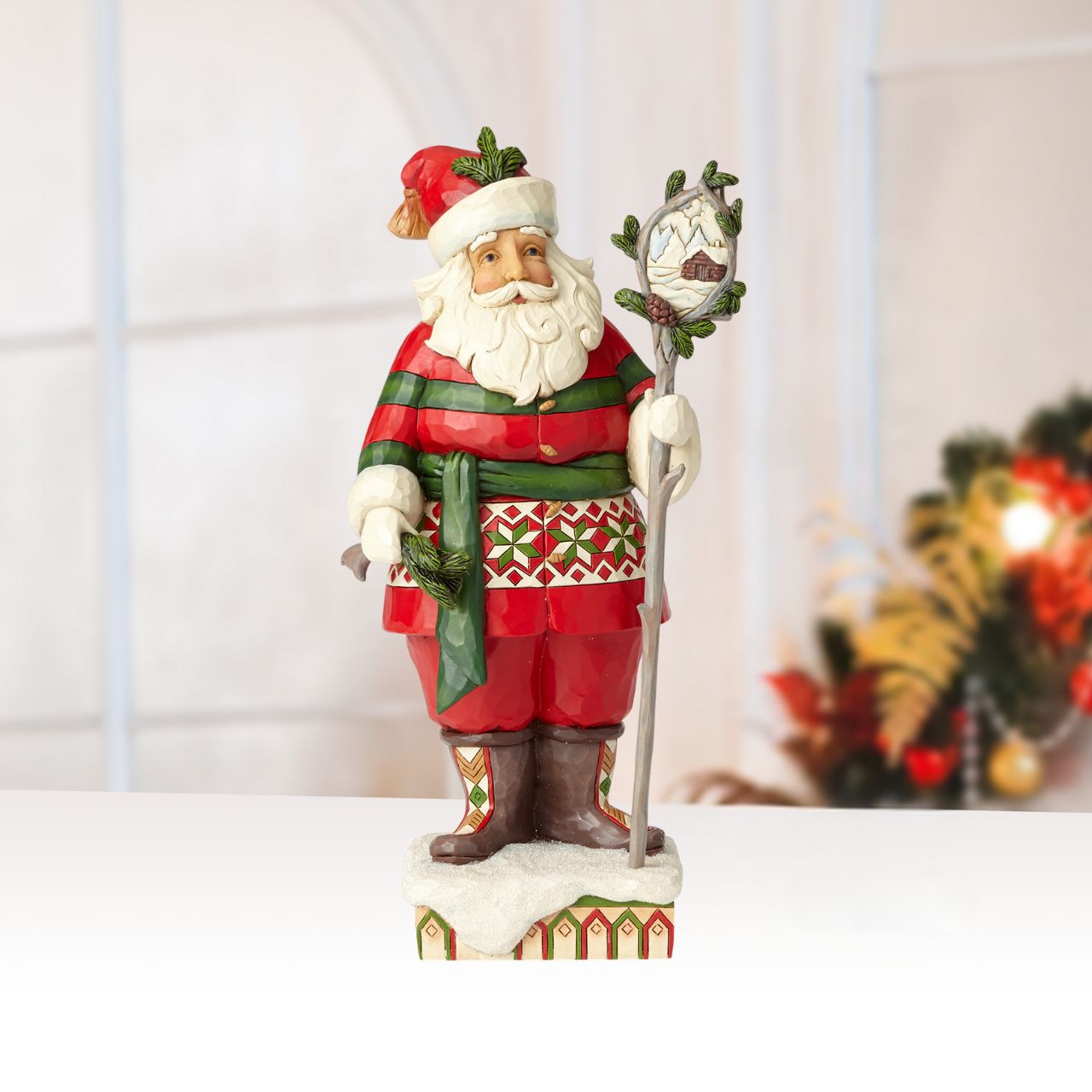 Heartwood Creek Wonder in the Wilderness - Woodsy Santa by Jim Shore The delight is in the details with this handcrafted Santa figurine. Intricate quilt patterns and folk art motifs detail his festive red and green attire, and a closer look at the staff he holds reveals a charming winter cabin scene.