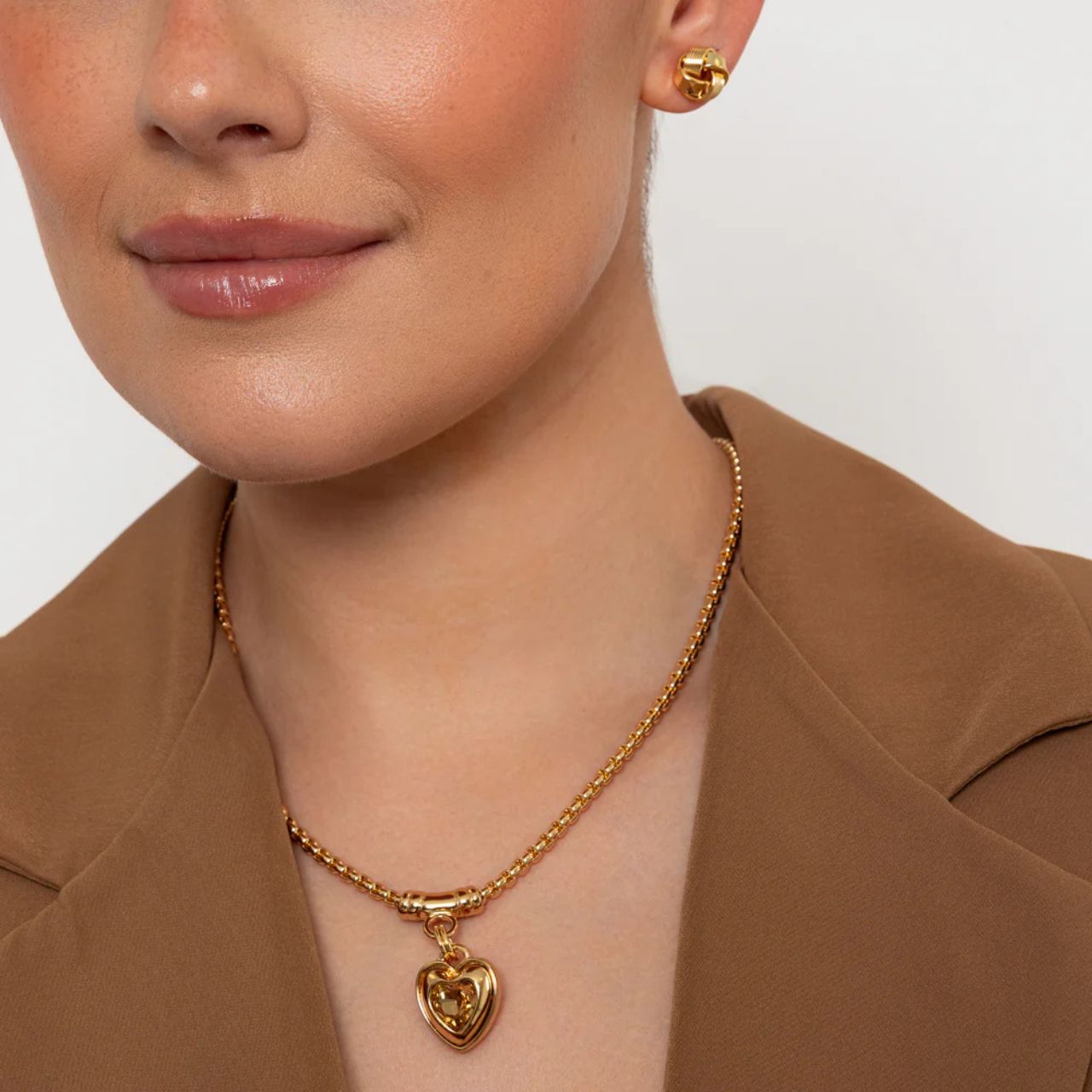 Elegant necklace with chunky heart drop embellished with golden shadow crystal.