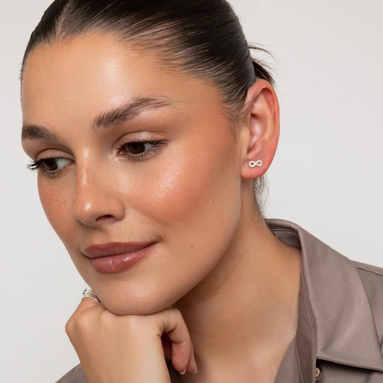Tiny Infinity earrings embellished with CZ stones. Stud fastening.