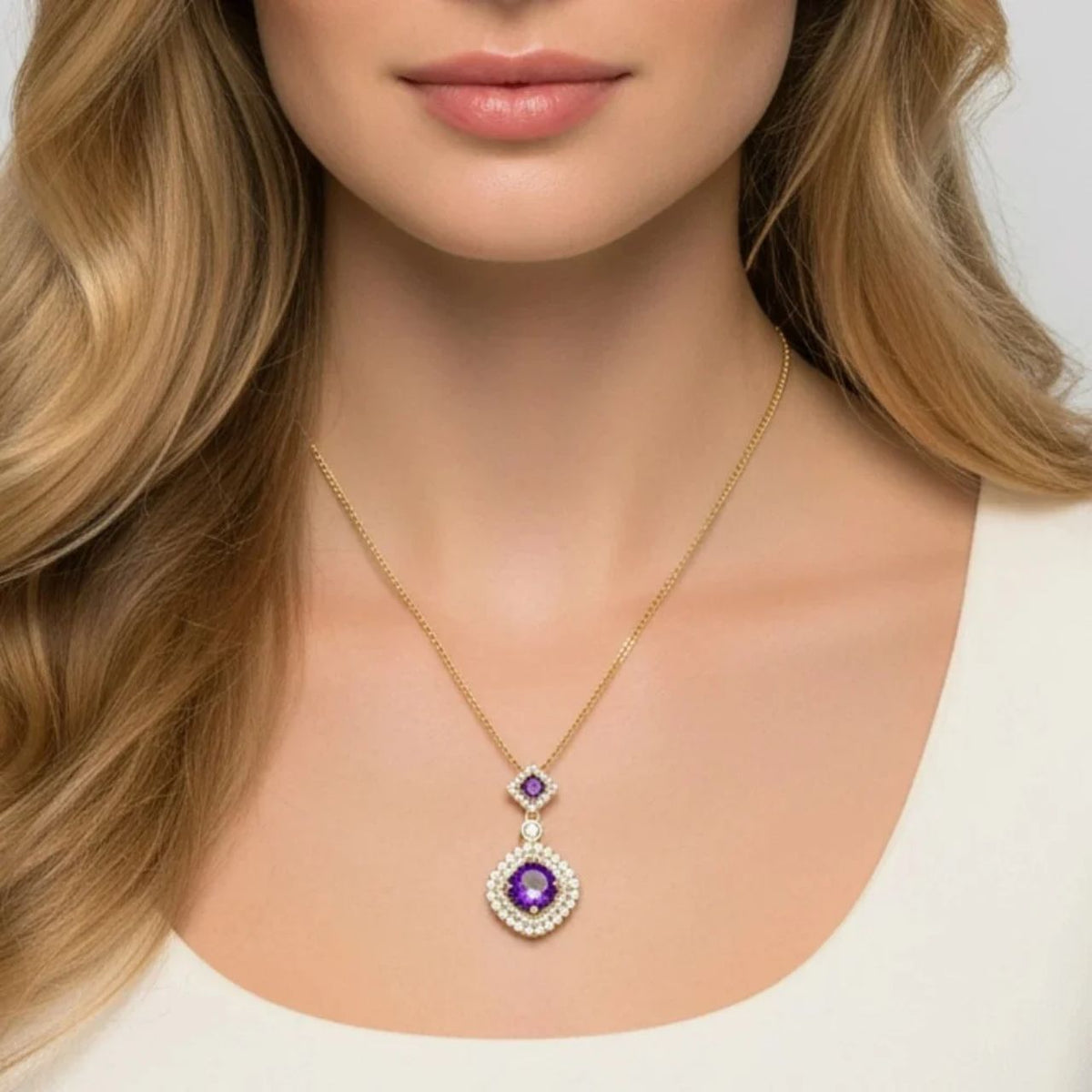Vintage style double drop pendant featuring gorgeous amethyst crystals arranged in sparkling CZ stone settings, all finished with luxurious gold plating.