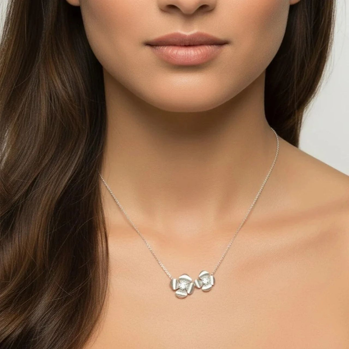 Delicate and effortlessly elegant, the Madelyn Necklace features two pretty floral shapes in brushed silver plating, beautifully embellished with sparkling CZ stones. Its fine, feminine design makes it a lovely choice for adding a subtle touch of elegance to any outfit.