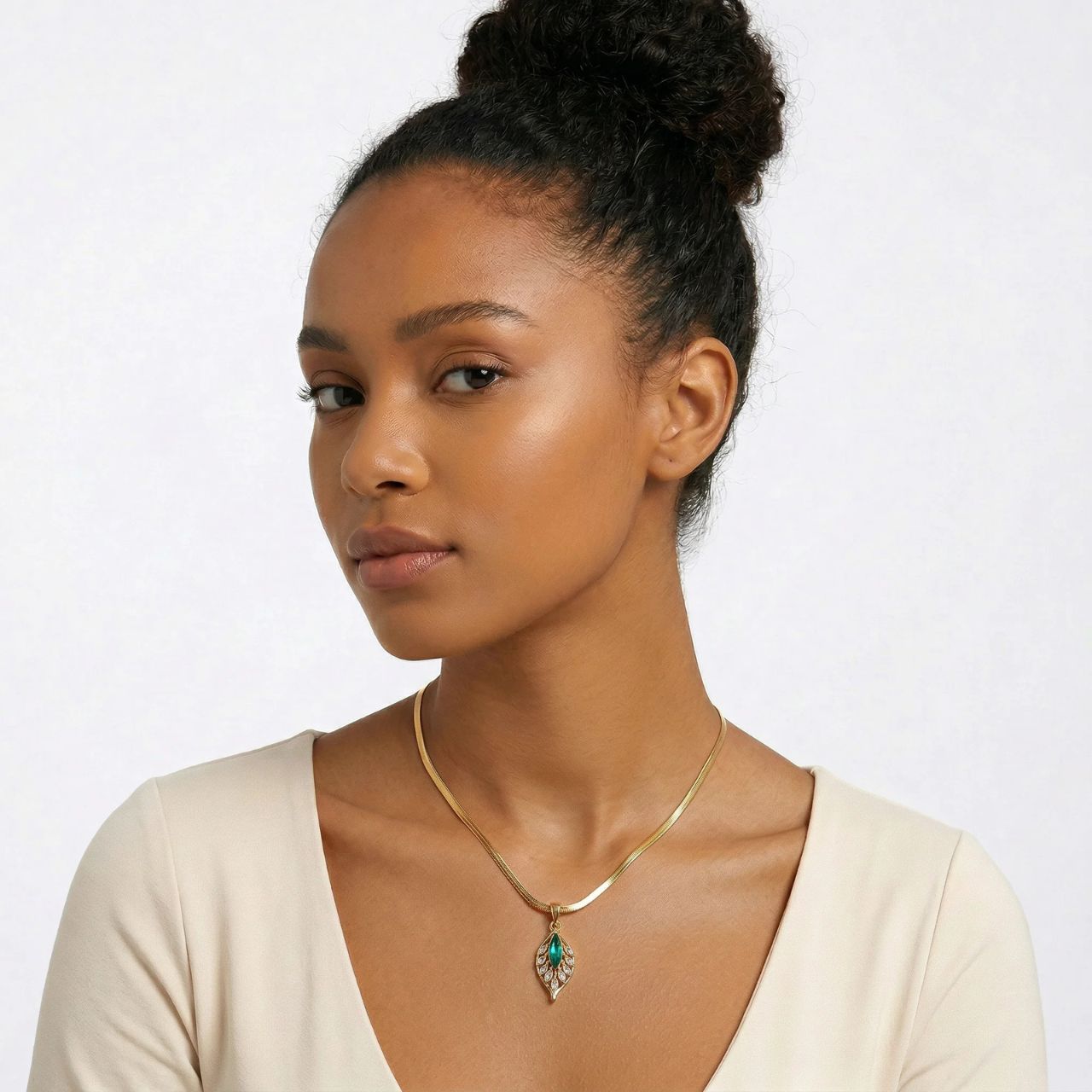 Beautiful leaf pendant embellished with green & clear crystal on an elegant snake chain necklace. The delicate design combines lustrous gold tones with sparkling gemstone accents for a sophisticated look.