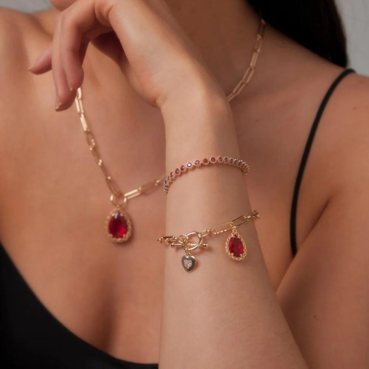 Mariana Garnet Bracelet by Knight & Day Tennis bracelet with garnet CZ stones & slider fastening. Gold plating.