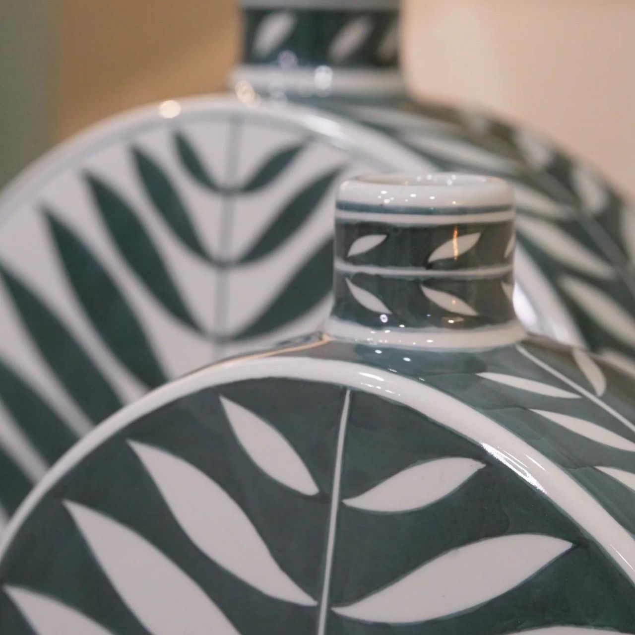 Leaf Bottle Small by Mindy Brownes This gorgeous ceramic decorative bottle will add a delicate pop of colour to your home. The calming colour pallet with it's green base and white leaf pattern will make this the perfect spring home accessory.