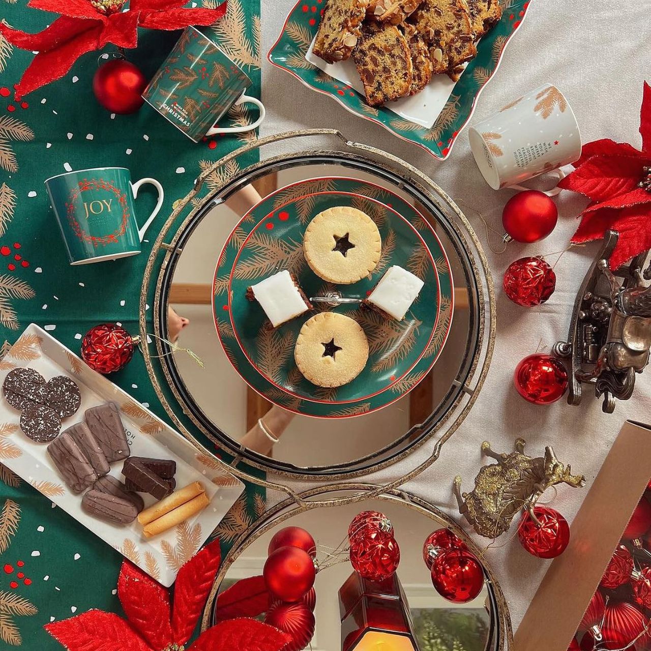 Christmas Festive Fir Two Tier Cake Stand by Mindy Brownes Interiors Introducing our Festive Fir collection. This charming collection is adorned with beautiful designs inspired by Christmas fir branches, red berries, and heart-warming holiday messages on green and white backgrounds.