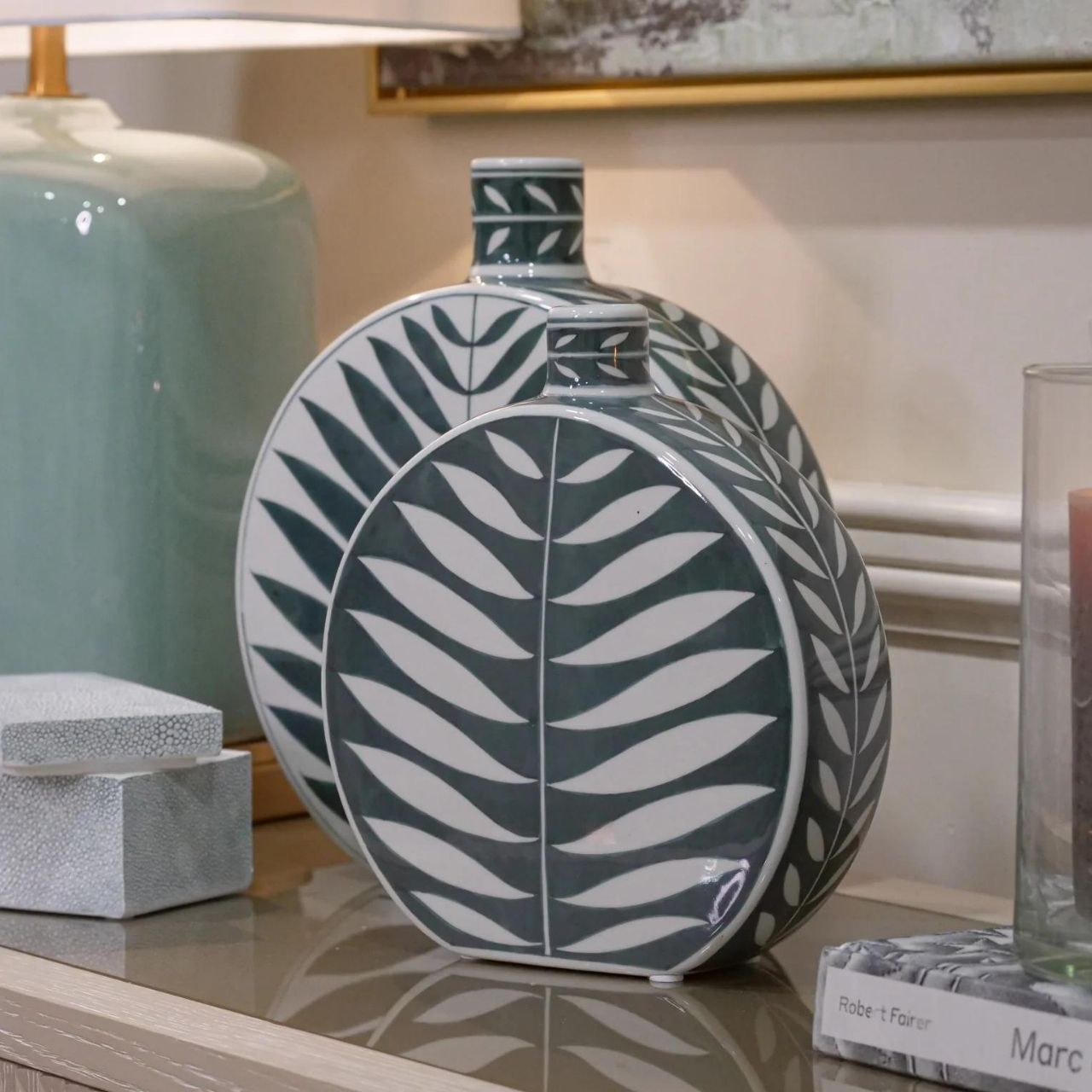 Leaf Bottle Small by Mindy Brownes This gorgeous ceramic decorative bottle will add a delicate pop of colour to your home. The calming colour pallet with it's green base and white leaf pattern will make this the perfect spring home accessory.