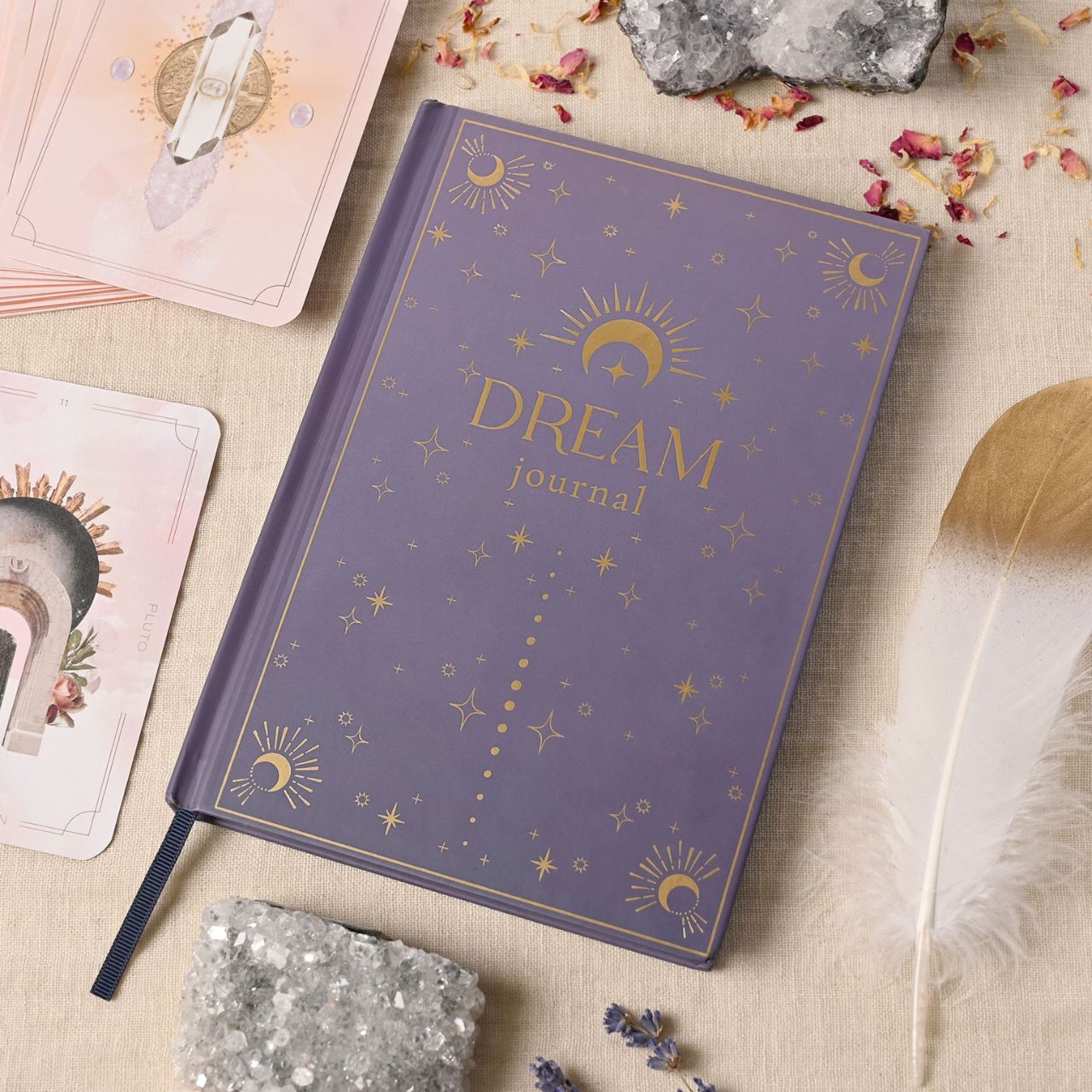 Introducing the enchanting Dream Diary, a captivating journal from the Mystic Legends Collection by Juliana. With its striking purple hardcover adorned with gold celestial designs of suns, moons, and stars, this dream diary is a perfect gift for those who love to explore their dreams and inner worlds.