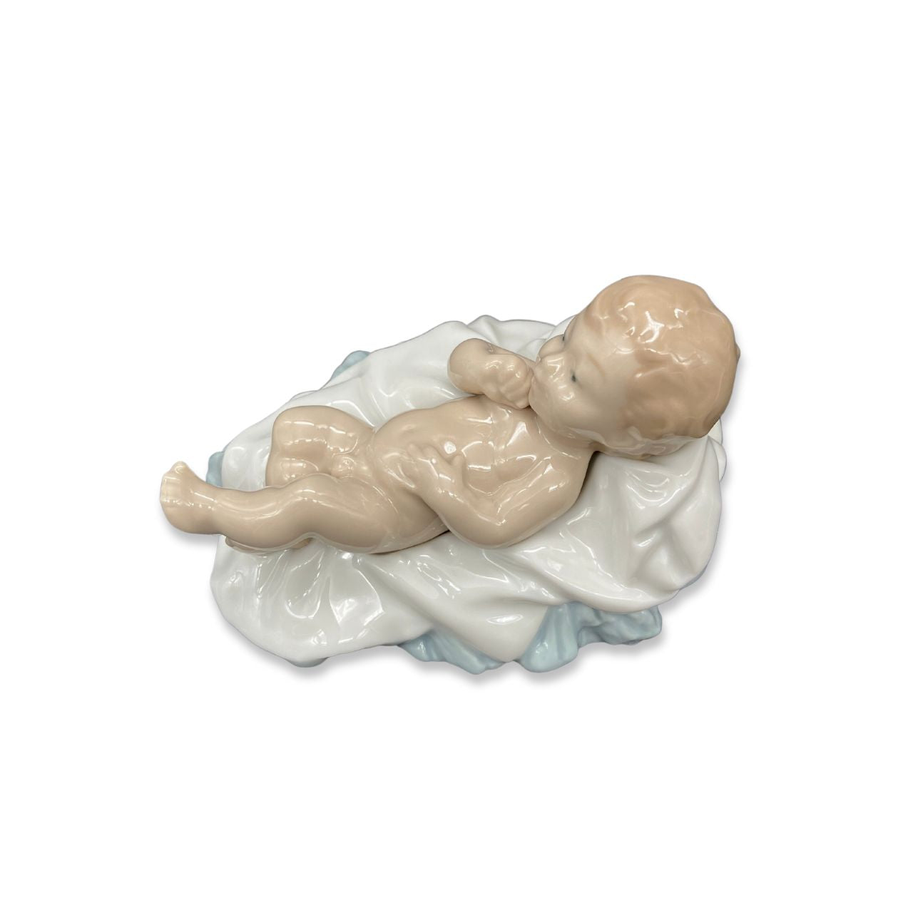 Nao by Lladro Baby Jesus  Nao porcelain figurine “Baby Jesus” from the Christmas Collection.  Sculpted by Salvador Furió, this figurine is part of the nativity set.  Nao Porcelain Figurines are produced in Valencia Spain and the Company is part of the Lladro family. Each piece is lovingly handmade and hand painted by the Valencia Artisans.
