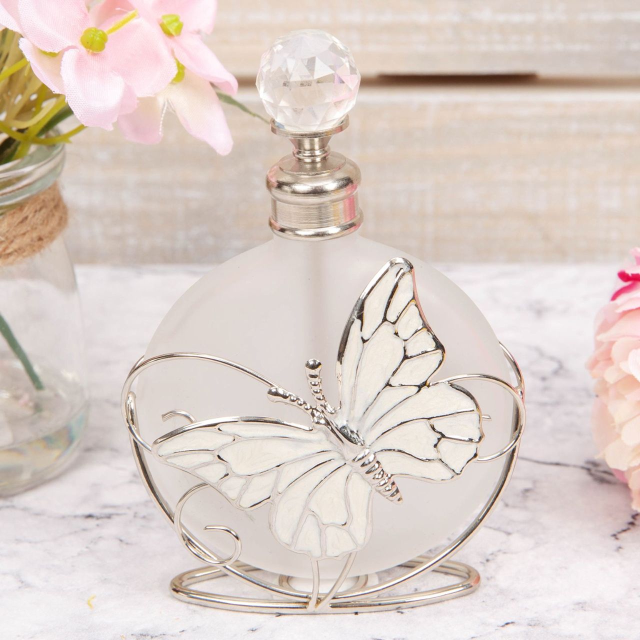 Perfume Bottle Glass & Wire with Butterfly An elegant frosted glass perfume bottle with an intricate handmade wire butterfly design and cut crystal stopper. From SOPHIA - the home of style & sophistication in women's giftware.