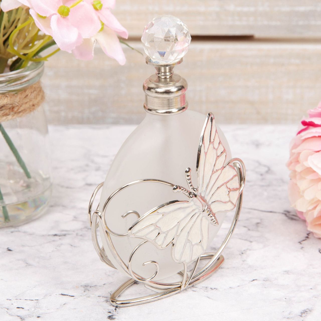 Perfume Bottle Glass & Wire with Butterfly An elegant frosted glass perfume bottle with an intricate handmade wire butterfly design and cut crystal stopper. From SOPHIA - the home of style & sophistication in women's giftware.